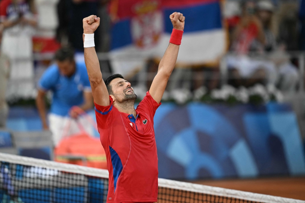 Serbia's Novak Djokovic celebrates beating Italy's Lorenzo Musetti during their men's singles semi-final tennis match on Court Philippe-Chatrier at the Roland-Garros Stadium during the Paris 2024 Olympic Games, in Paris on August 2, 2024.   (Photo by CARL DE SOUZA / AFP)

