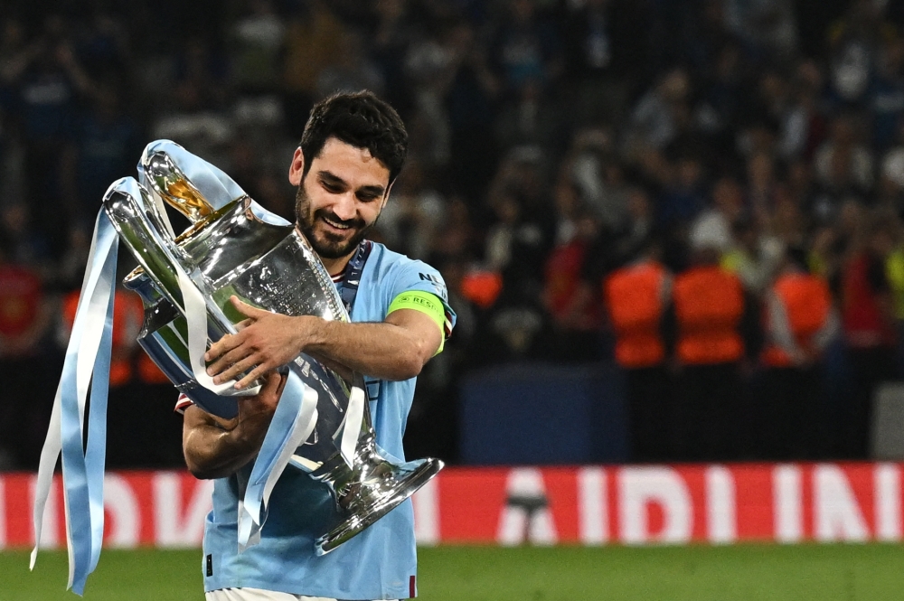 Manchester City's German midfielder #8 Ilkay Gundogan poses with the European Cup trophy as they celebrate winning the UEFA Champions League final football match 