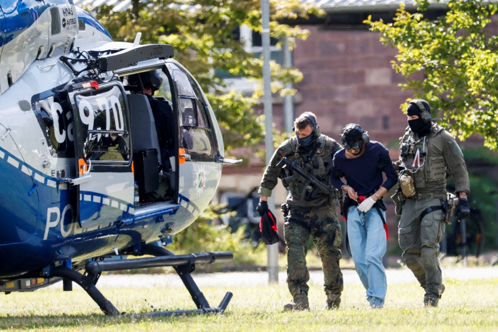 A 26-year-old Syrian man is escorted by police as he leaves the Federal Public Prosecutor in Karlsruhe, Germany. — AFP 