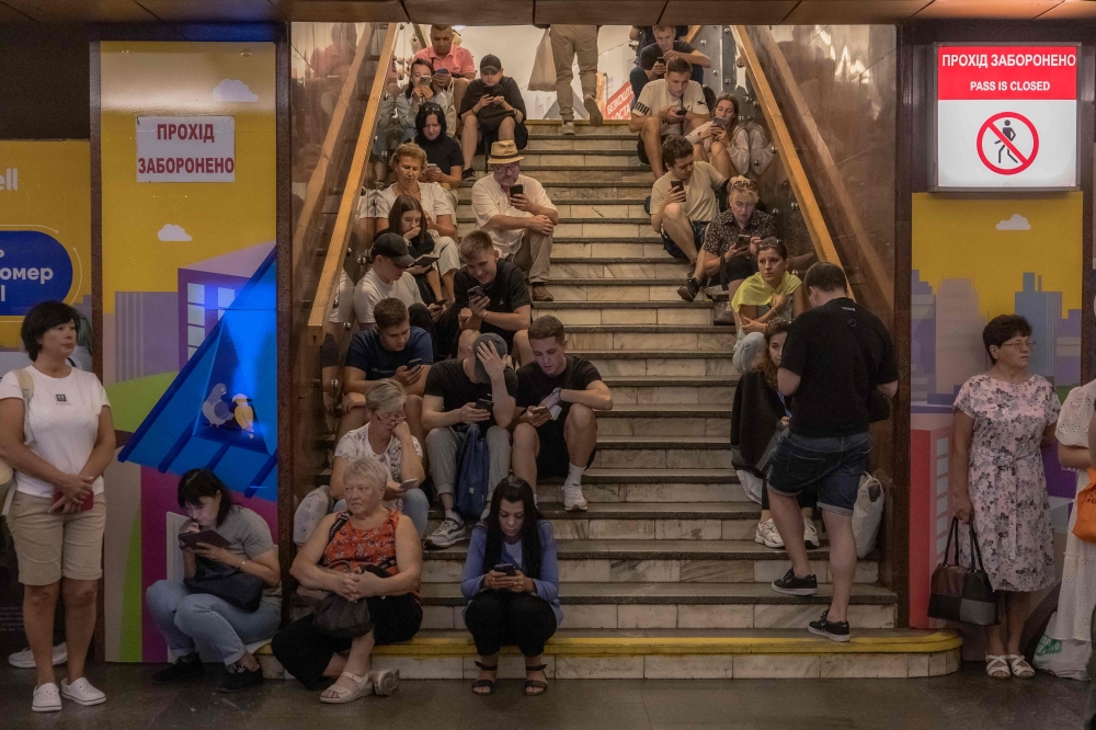 People take shelter in the Teatralna metro station during a Russian air attack, in Kyiv. — AFP 