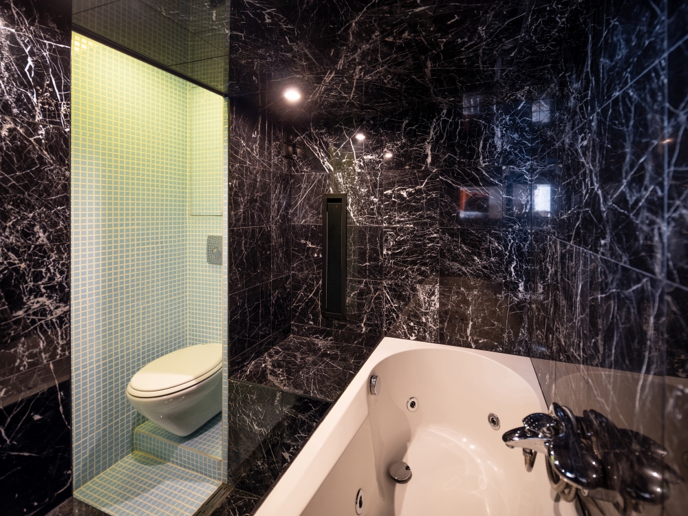 A 23-square-foot black marble spa connects to a 12-square-foot, sky-blue shower room with a toilet in the tiny apartment designed by Beatriz Ramo L
