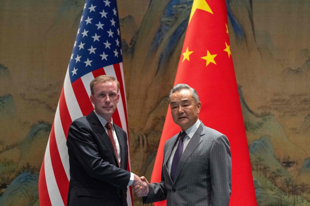China's Foreign Minister Wang Yi (R) shakes hands with US National Security Advisor Jake Sullivan at Yanqi Lake in Beijing. — AFP