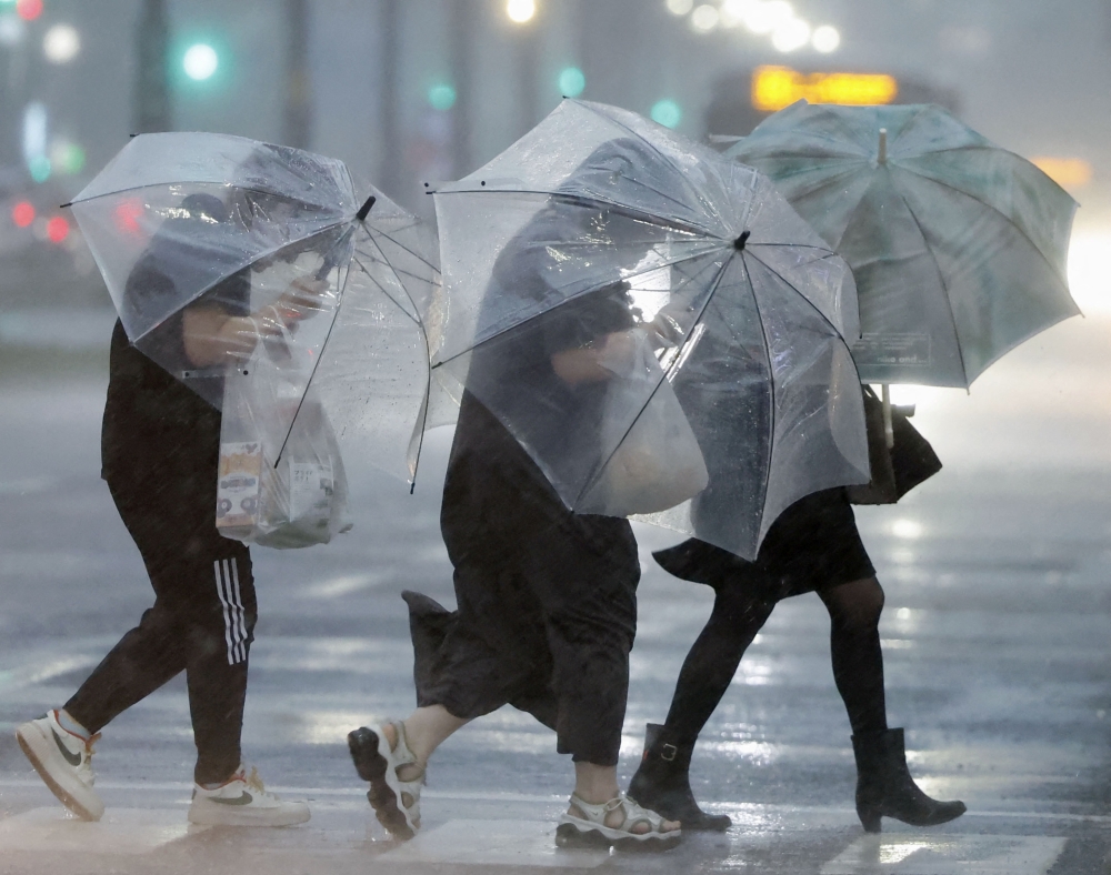 Pedestrians holding umbrellas struggle against strong wind and heavy rains caused by Typhoon Shanshan in Kagoshima, southwestern Japan August 28, 2024, in this photo taken by Kyodo. Mandatory credit Kyodo/via REUTERS ATTENTION EDITORS - THIS IMAGE WAS PROVIDED BY A THIRD PARTY. MANDATORY CREDIT. JAPAN OUT. NO COMMERCIAL OR EDITORIAL SALES IN JAPAN   Mandatory credit Kyodo/via REUTERS