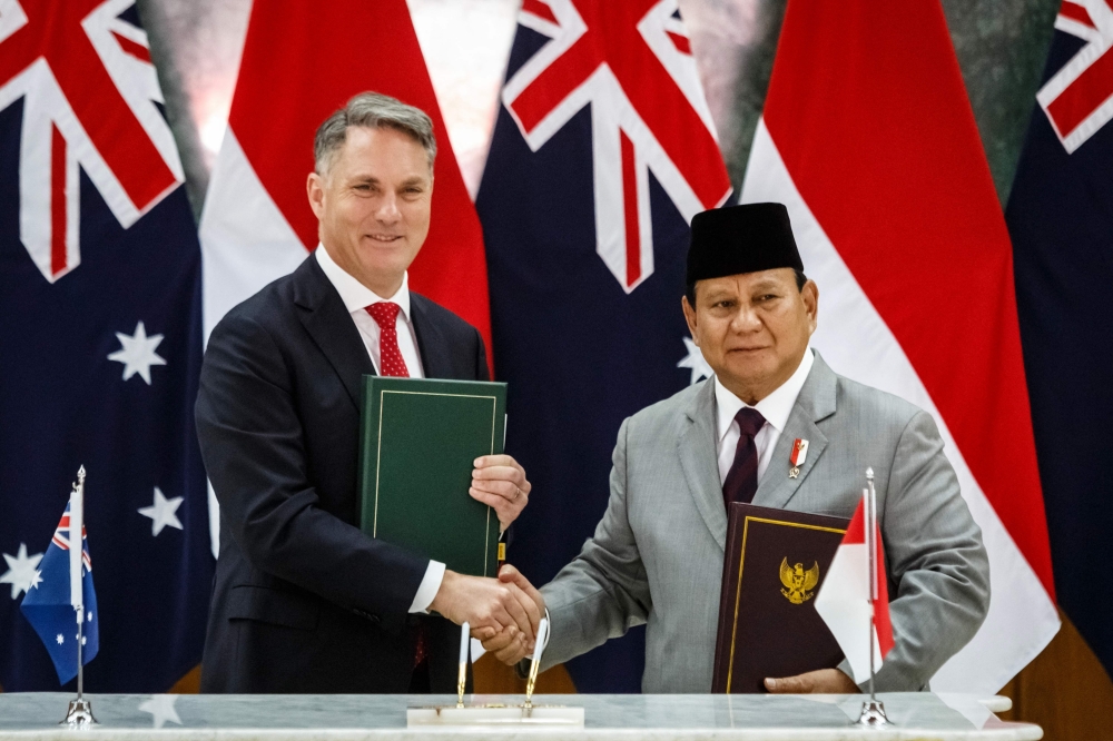 Indonesia's Defence Minister and president-elect Prabowo Subianto (R) and Australia's Deputy Prime Minister and Defence Minister Richard Marles shake hands after signing the Australia-Indonesia Defence Cooperation Agreement (DCA) at the Military Academy in Magelang, Central Java, on August 29, 2024. The pact, which includes provisions for joint drills and deployments to each country, was signed during Marles' visit to Indonesia this week. (Photo by DEVI RAHMAN / AFP)

