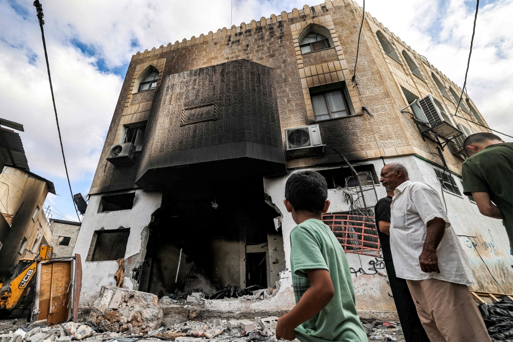 People inspect damage to a mosque building following an Israeli military operation in the Fara camp for Palestinian refugees near Tubas in the north of the occupied West Bank on August 29, 2024. Israel on August 28 launched a large-scale operation in the occupied West Bank where the military said it killed Palestinian fighters, as the nearly 11-month-old Gaza war showed no signs of abating. (Photo by Zain JAAFAR / AFP)
