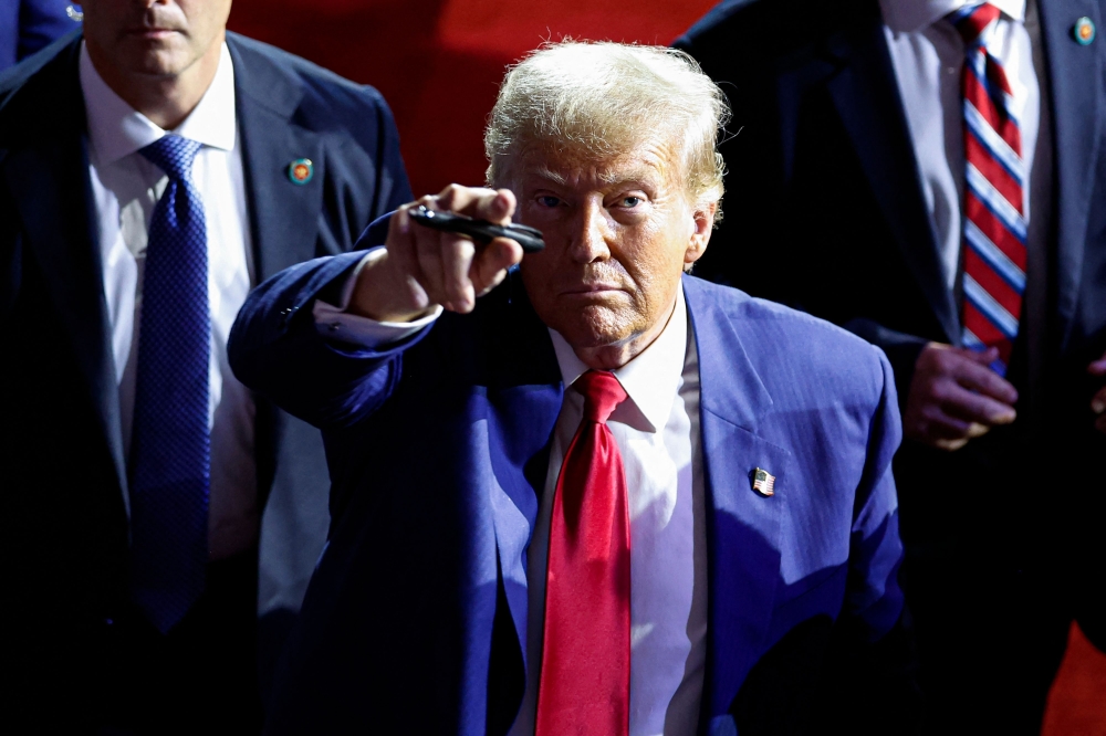 Former US president and Republican presidential candidate Donald Trump points to the crowd as he leaves after speaking during a town hall meeting in La Crosse 