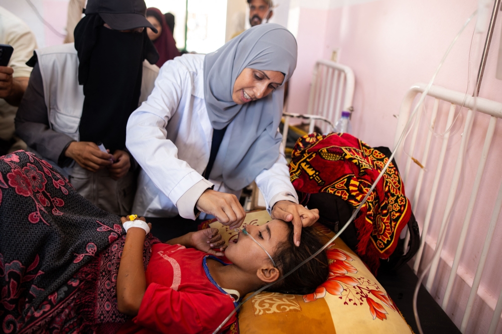 A nurse administers Polio vaccine drops to a young Palestinian patient at the Nasser hospital in Khan Yunis in the southern Gaza Strip on August 31, 2024, amid the ongoing conflict between Israel and the Hamas militant group. The World Health Organization said Israel had agreed to at least three days of "humanitarian pauses" in parts of Gaza, starting on August 31, to facilitate a vaccination drive after the territory recorded its first case of polio in a quarter of a century. (Photo by Jihad Al-Sharafi / AFP)

