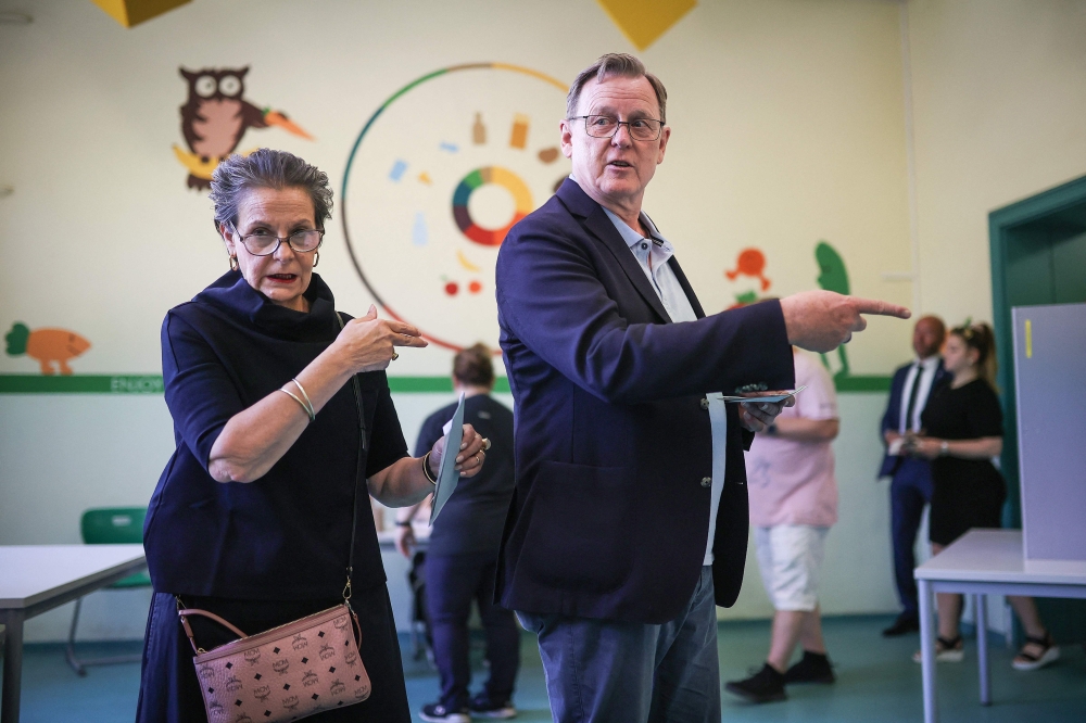 Thuringia's State Premier and top candidate of the left-wing Die Linke party for regional elections in Thuringia Bodo Ramelow (R) and his wife Germana Alberti vom Hofe (L) gesture at a polling station in Erfurt, eastern Germany. — AFP 