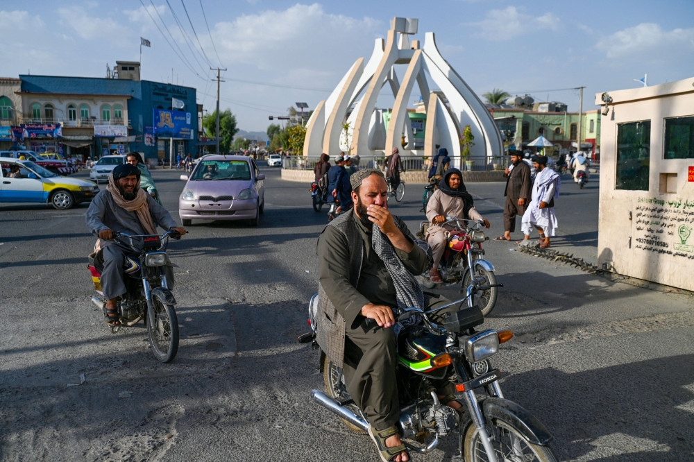 Afghan men ride motorcycles along a road in Kandahar. — AFP file photo 