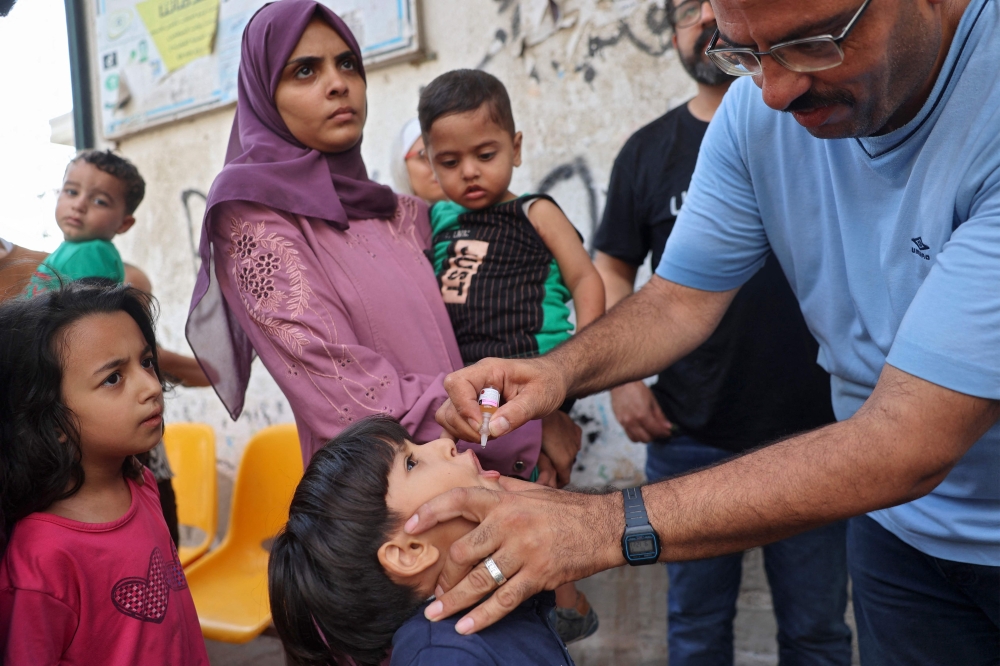 A health worker marks the finger of a Palestinian child that was vaccinated against Polio in Zawayda in the central Gaza Strip