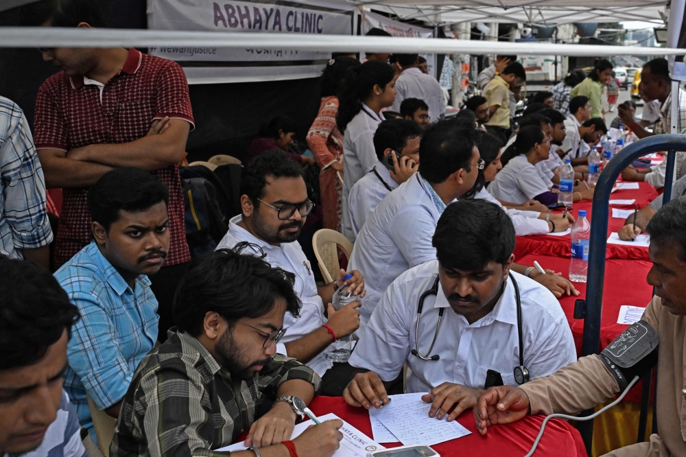 Junior doctors attend patients and distribute free medicines at Abhaya Clinic, a temporary medical camp, along a street in Kolkata 