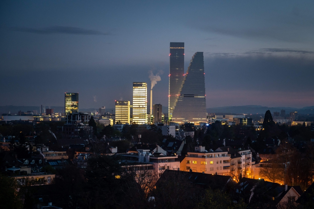 (FILES) A picture taken early on April 5, 2023 shows the two towers (R),   designed by architects Herzog and de Meuron, housing the headquarters of Swiss pharma giant Roche in Basel. Basel will host the 2025 Eurovision Song Contest after being chosen ahead of Geneva on Friday to stage the 69th edition of the glitzy TV extravaganza. (Photo by Fabrice COFFRINI / AFP)

