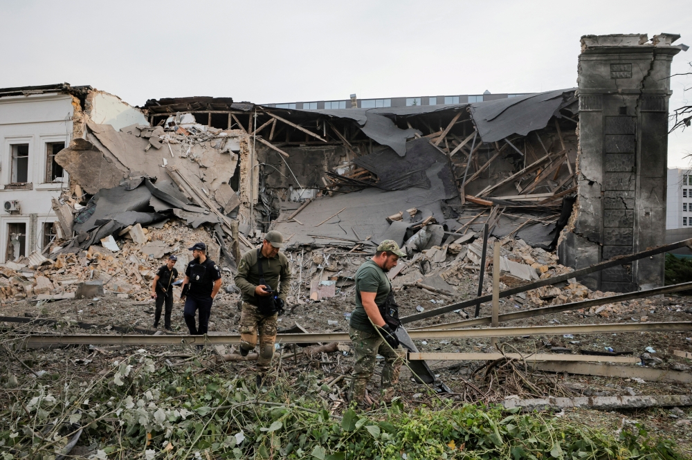 Investigators inspect the site of the Russian missile strike on an office building, in Kyiv. — Reuters 