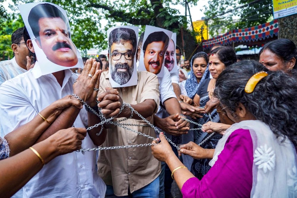 Indian National Congress (INC) party workers wear masks of celebrities from the country's Kerala-based Mollywood film industry