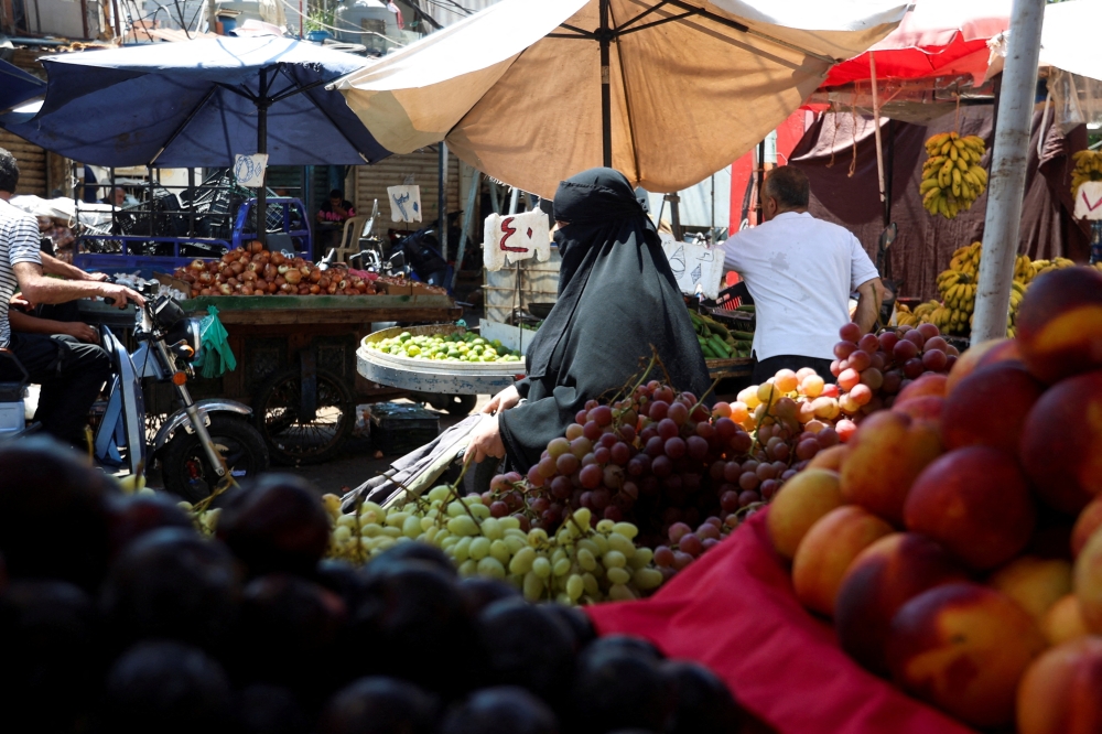 A veiled woman shops at a crowded souk, in Sabra, Beirut suburbs, Lebanon August 29, 2024. REUTERS/Ahmed Saad
