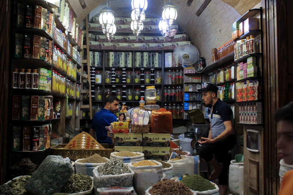 A vendor works inside a shop which has reopened after undergoing extensive restoration after enduring significant damage from the Syrian war, at Aleppo's old souks, in Aleppo, Syria August 28, 2024. REUTERS/Firas Makdesi
