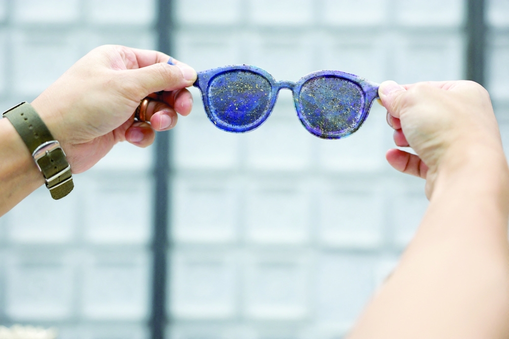 Arthur Huang, founder of Miniwiz, the company that runs Trash Kitchen, holds a pair of sunglasses made with plastic waste in Taipei, Taiwan.