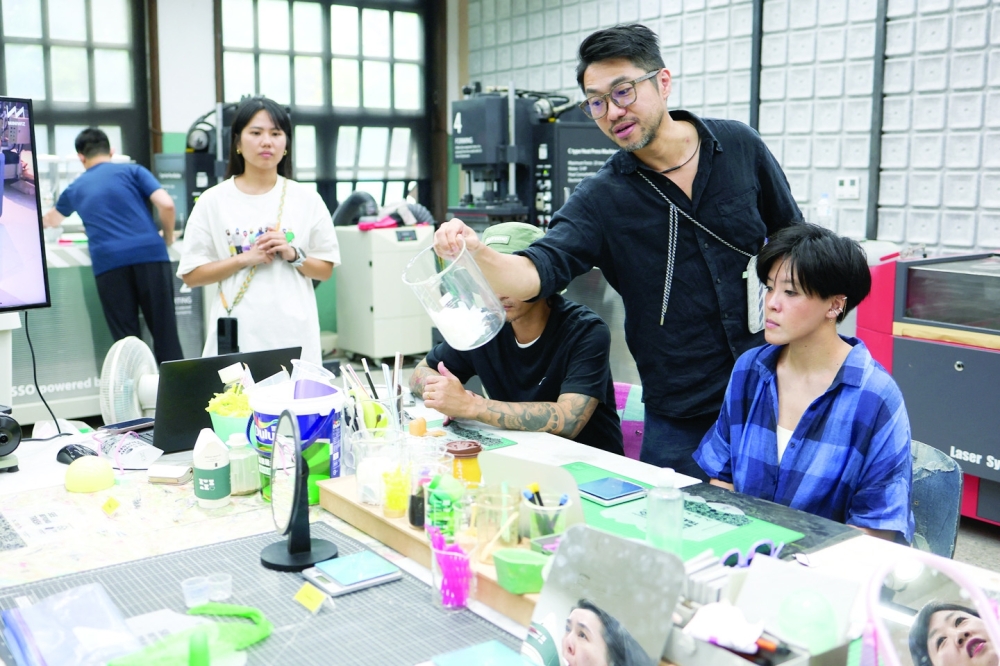 Arthur Huang, founder of Miniwiz, the company that runs Trash Kitchen, holds a jar of plastic waste that will be turned into frames of sunglasses at his workshop in Taipei, Taiwan.