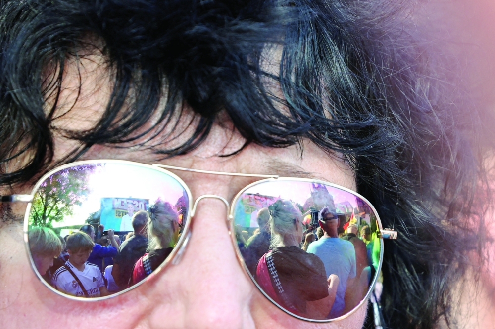Germany's Alternative for Germany (AfD) party leader in Thuringia state Bjoern Hoecke is reflected in an attendee's sunglasses as he appears on a screen while speaking during an election campaign rally for the Thuringia state elections, in Erfurt, Germany.