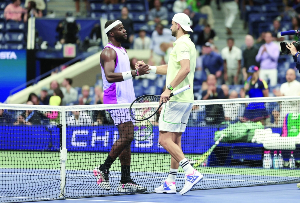 USA's Frances Tiafoe (L) and Bulgaria's Grigor Dimitrov (R) meet at the net after Dimotrov retired due to injury during their men's quarterfinals match on day nine of the US Open tennis tournament at the USTA Billie Jean King National Tennis Center in New York City.