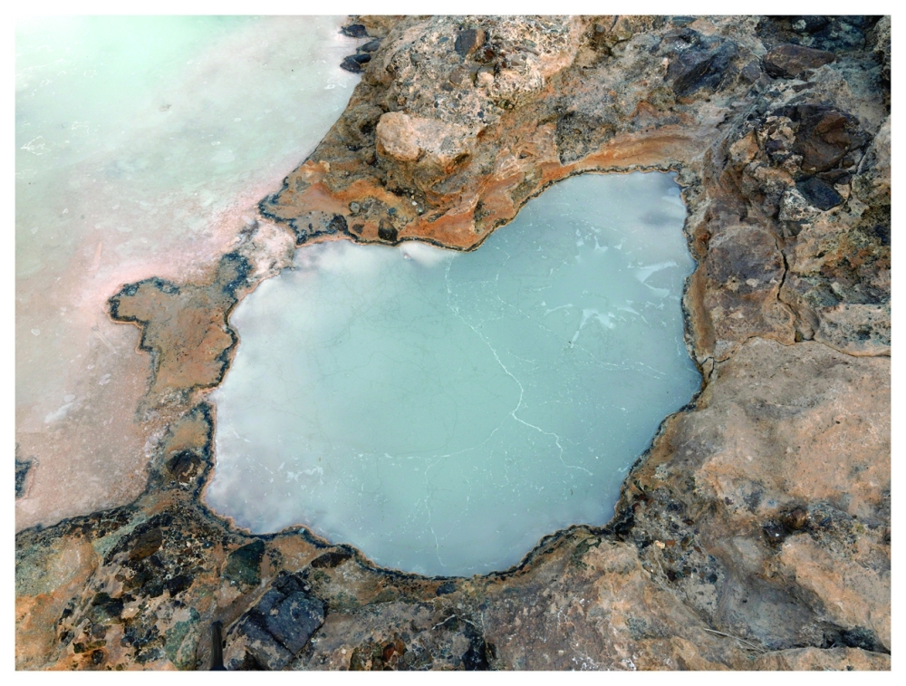 A thin layer of carbonate hardening across the surface of water, in Oman.