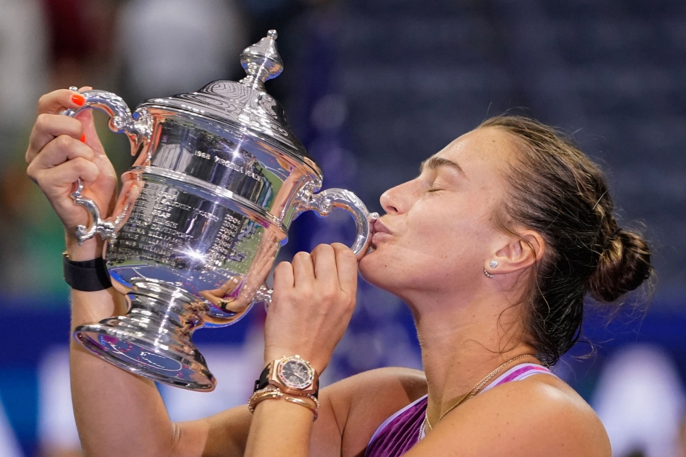 TOPSHOT - Belarus's Aryna Sabalenka kisses the trophy after defeating USA's Jessica Pegula during their women's final match on day thirteen of the US Open tennis tournament at the USTA Billie Jean King National Tennis Center in New York City, on September 7, 2024. (Photo by TIMOTHY A. CLARY / AFP)


