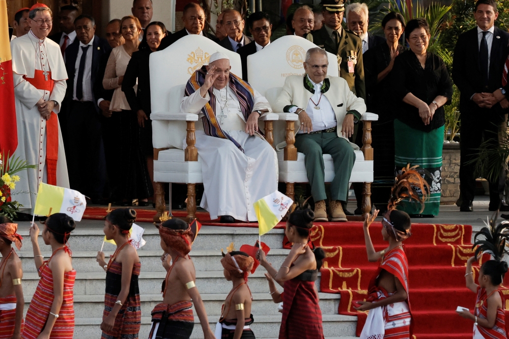 Pope Francis greets youths in traditional dress as East Timor's President Jose Ramos-Horta looks on during a welcoming ceremony at the Presidential Palace in Dili, East Timor, September 9, 2024.     YASUYOSHI CHIBA/Pool via REUTERS
