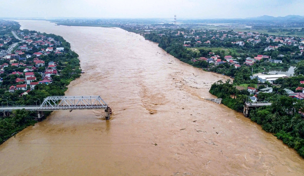 TOPSHOT - This aerial picture shows the collapsed Phong Chau bridge over the Red River in Phu Tho province on September 9, 2024, after Super Typhoon Yagi hit northern Vietnam. Yagi, the most powerful typhoon to hit northern Vietnam in 30 years according to meteorologists, downed bridges, tore roofs off buildings and damaged factories after making landfall on September 7, 2024. (Photo by AFP)