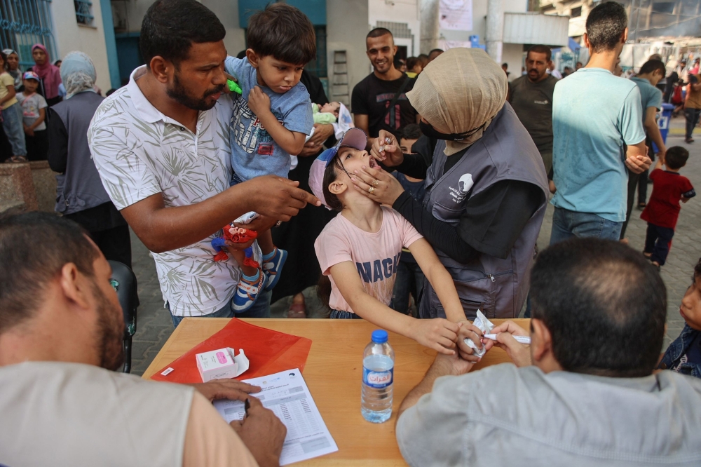 Palestinian medics administer polio vaccines to children at the al-Daraj neighborhood clinic in Gaza City. — AFP 