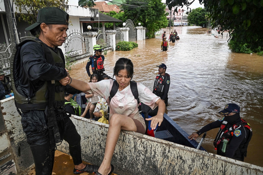 Local rescue teams pick up schoolchildren and residents during flooding in the northern Thai city of Chiang Rai. - AFP