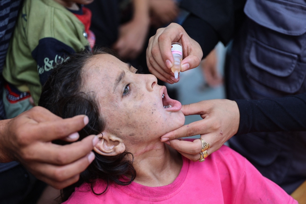 A medic administers a polio vaccine to a Palestinian girl at the Al Daraj neighbourhood clinic in Gaza City. - AFP