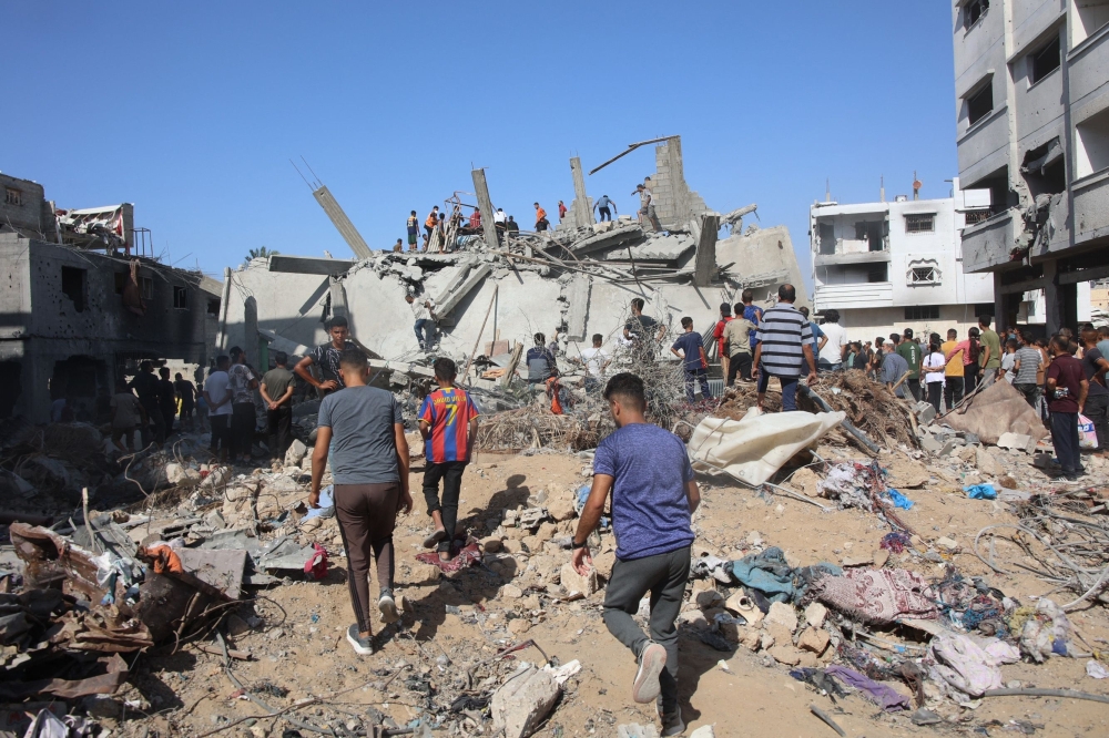 Palestinians search in the rubble for survivors at the site of an Israeli strike in the Shejaiya suburb east of Gaza City on Thurysday. - AFP