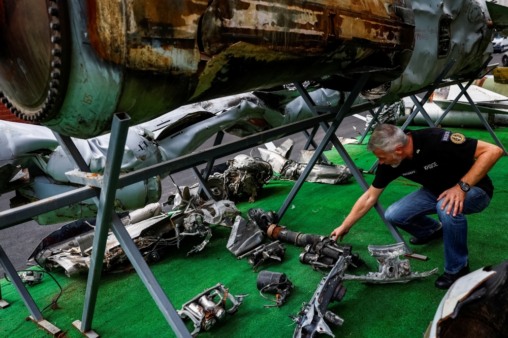 An expert of the Kyiv Scientific Research Institute of Forensic Expertise shows parts of a Kh-47 Kinzhal Russian hypersonic missile