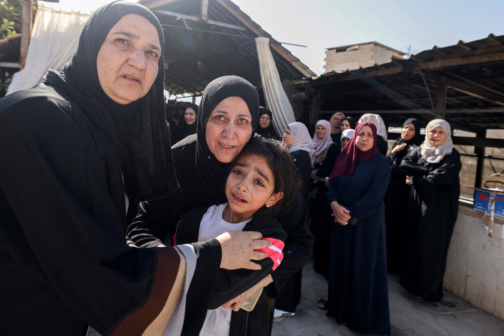 Palestinian relatives cry during the funeral procession of men killed in an Israeli air strike in Tubas, amid an ongoing military raid 