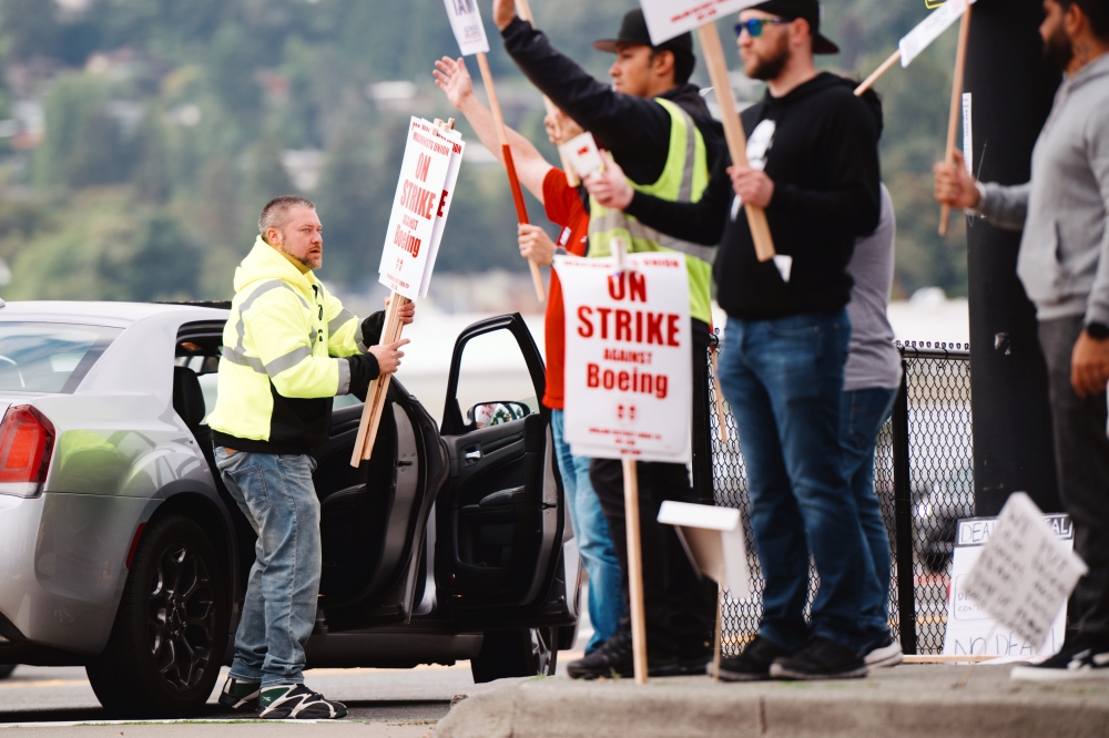 Striking workers picket outside of a Boeing production facility in Renton