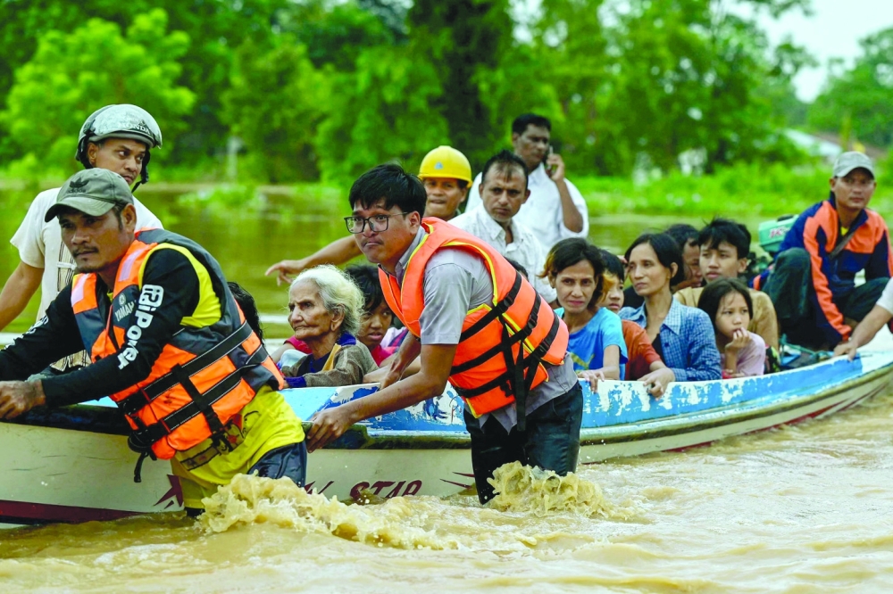 Flood-affected residents are transported on a rescue boat in Taungoo, Myanmar's Bago region. — AFP