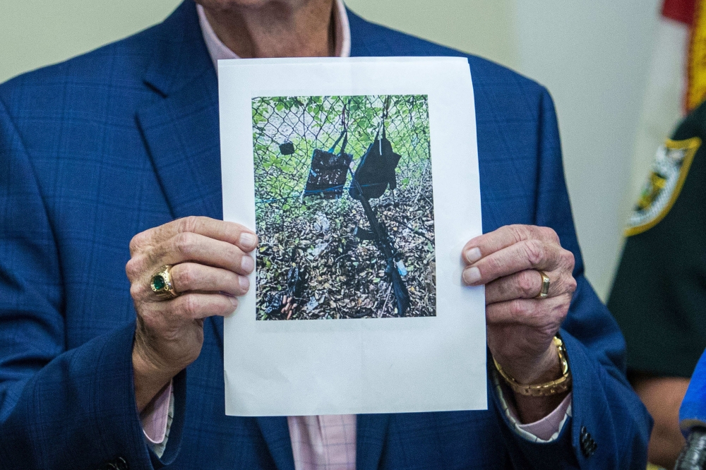 Sheriff Ric Bradshaw of Palm Beach County holds up a photo showing items that belong to the suspect 