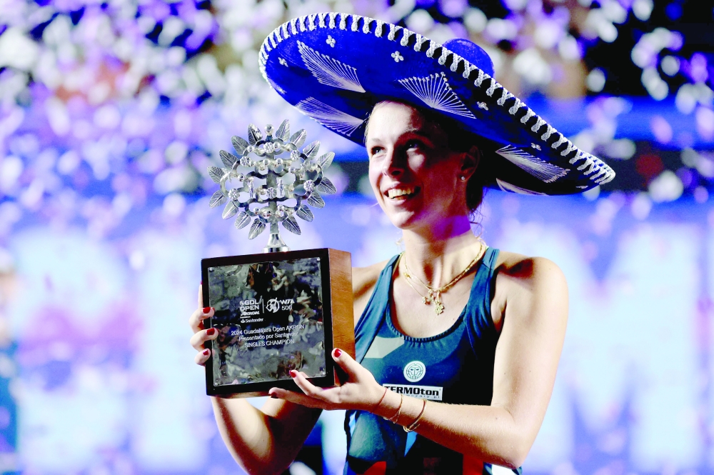 Poland's Magdalena Frech celebrates with her trophy on the podium after winning the women's singles final of the WTA Guadalajara Open tennis tournament in Zapopan, Mexico, on September 15, 2024. Frech defeated Australia's Olivia Gadecki in the final. (Photo by ULISES RUIZ / AFP)

