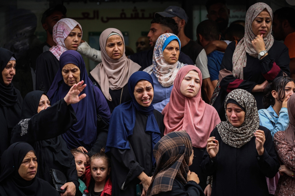 Palestinian women mourn people killed in Israeli strikes on the Bureij refugee camp. — AFP 