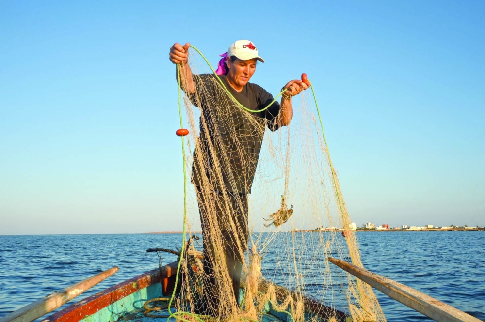 Tunisian fisherwoman Sara Souissi prepares her net in a boat along the coast of Tunisia's Kerkennah Islands in the Mediterranean Sea in the south of the country, on August 8, 2024. Souissi began fishing as a teenager in a family of fishers off their native Kerkennah Islands near the city of Sfax, defying men who believed she had no place at sea. A substantial portion of Tunisia is coastal or near the coast, making the sea an essential component of everyday life.