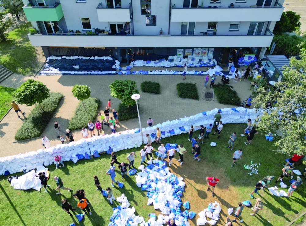 General view taken by drone of soldiers and civilian volunteers securing buildings and streets against flooding of the Bystrzyca river with sandbags in Wroclaw, Poland. - Reuters