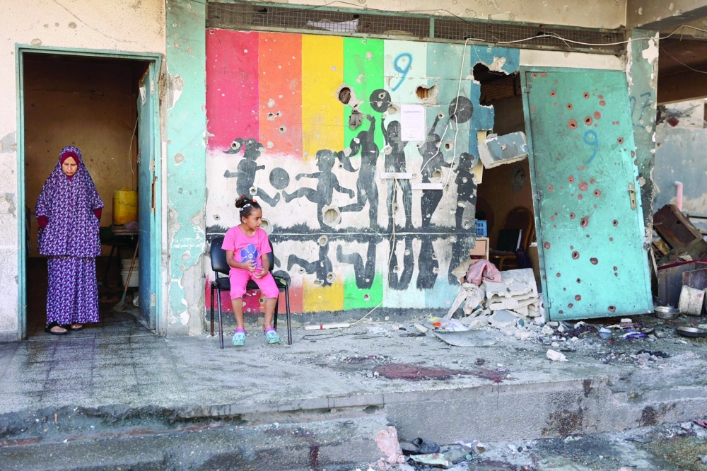Displaced Palestinians inspect the damage at the site of an Israeli strike on a school housing displaced Palestinians in Gaza. — AFP 