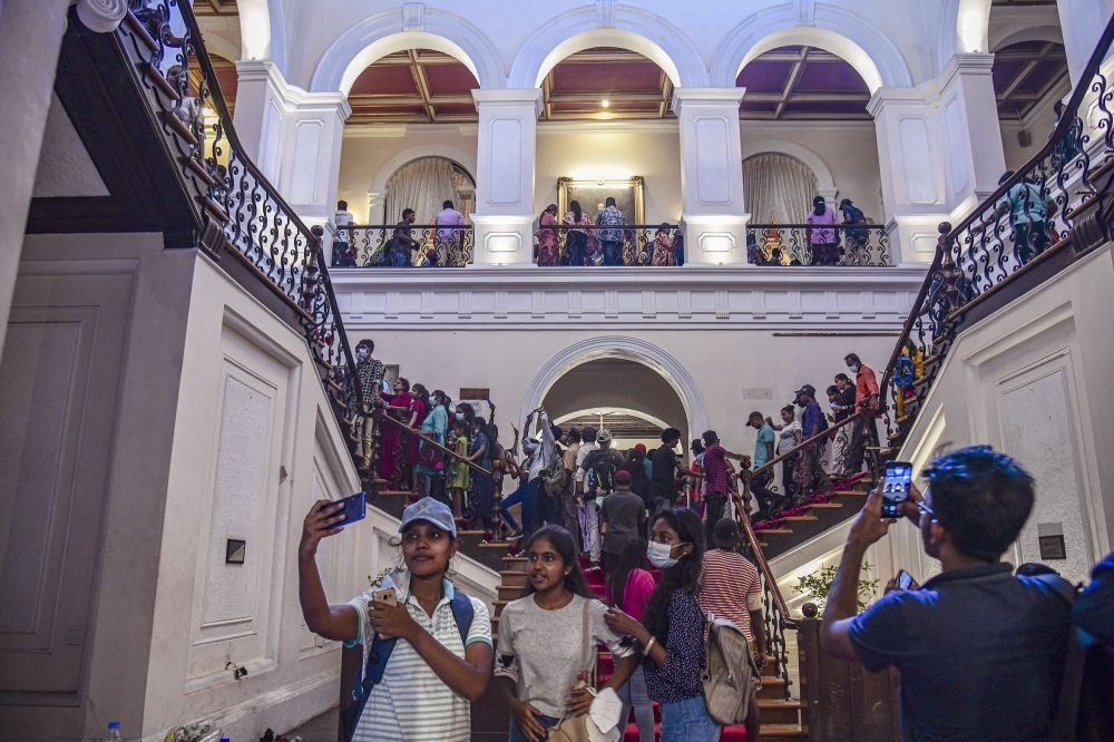 People walk through the presidential palace in Colombo, Sri Lanka, after protesters took control on July 12, 2022. (Atul Loke/The New York Times)