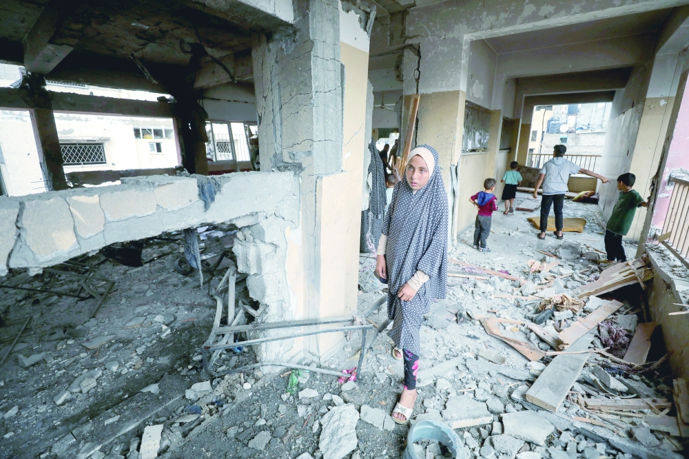 Palestinians inspect the damage to a school sheltering displaced people after it was hit by an Israeli strike, at Beach refugee camp in Gaza City. — Reuters 