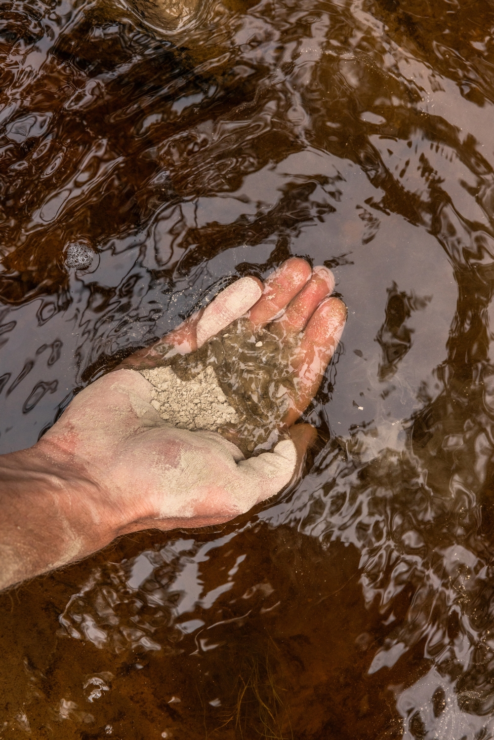 Luke Connell, CarbonRuns chief executive, demonstrates how lime and water mix into the river in Nova Scotia, Canada, Aug. 26, 2024. (Greta Rybus/The New York Times)