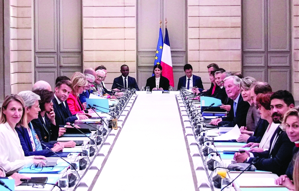 French President Emmanuel Macron (L) and French Prime Minister Michel Barnier (R) meet with members of the new government during the weekly cabinet meeting at the Elysee Palace, in Paris. — AFP  