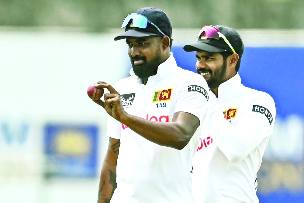 Sri Lanka's Prabath Jayasuriya (L) gestures with the ball after taking a five-wicket haul during the fifth day of the first Test cricket match between Sri Lanka and New Zealand at the Galle International Cricket Stadium in Galle on September 23, 2024. 
