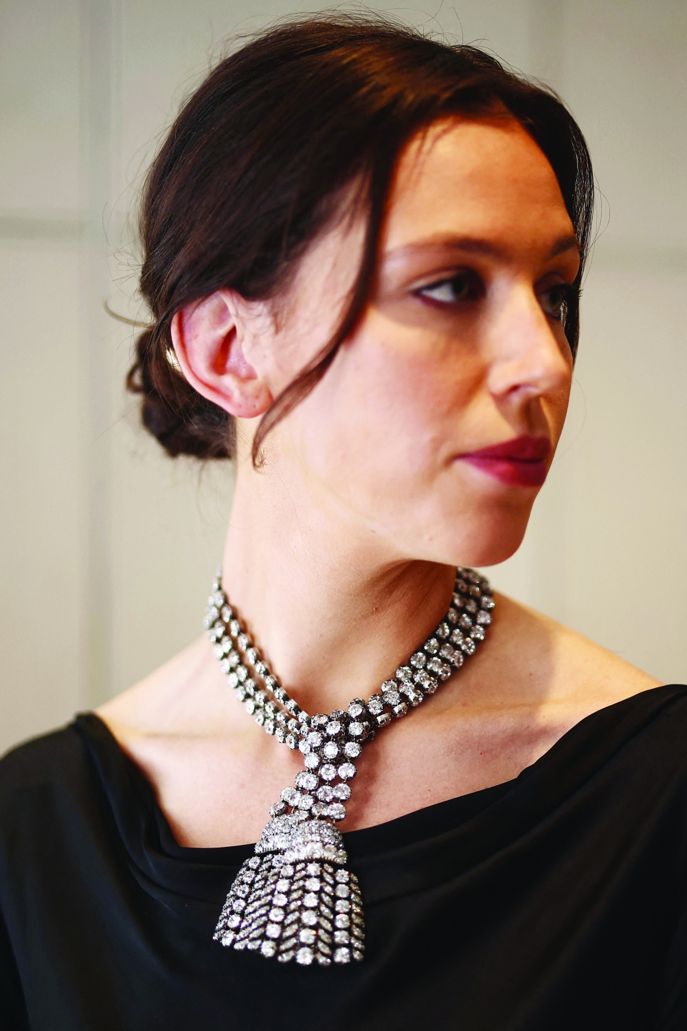 A gallery assistant poses wearing an 18th century diamond jewel necklace weighing approximately 300 carats at a press preview at Sotheby's in London on September 23, 2024. This necklace (is estimated to fetch £1,350,000 - £2,100,000 GBP, 1,620,000 - 2,500,000 Euro, $1,800,000 – $2,800,000 USD) and will be the highlight of Sotheby’s jewellery sales and auctioned as part of the Royal and Noble sale taking place in Geneva on November 11 ahead of the Magnificent Jewels sale on 13 November.