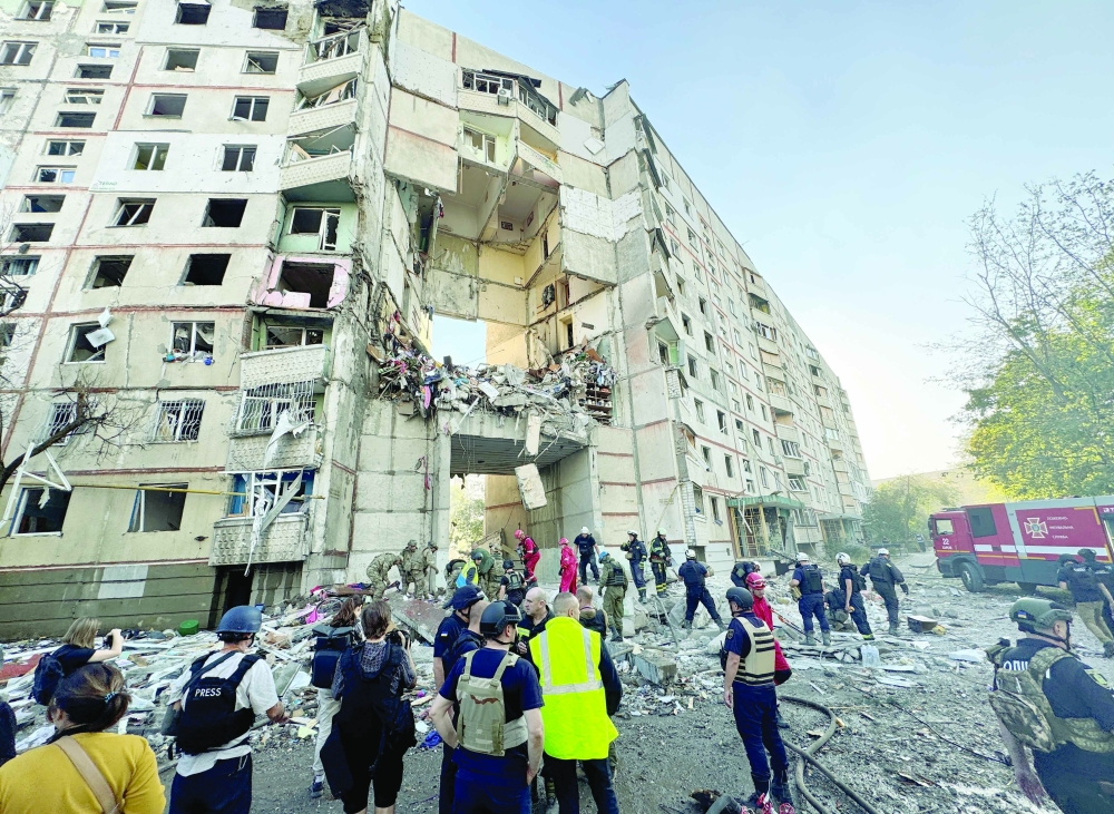 Firefighters and rescuers work at the site of an apartment building hit by a Russian air strike, in Kharkiv. — Reuters