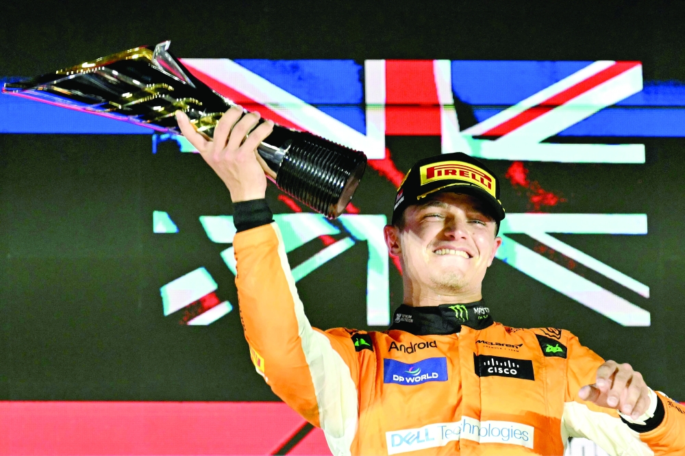 McLaren's British driver Lando Norris celebrates winning on the podium after the Formula One Singapore Grand Prix night race at the Marina Bay Street Circuit in Singapore on September 22, 2024. 